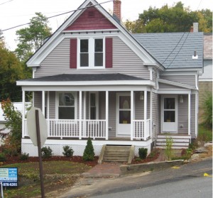 a house with pale mauve siding, white doors, and front porch with white railings