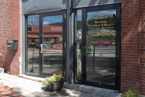 the entrance to a brick building with a glass door labeled: Holistic Chiropractic & Reiki, Robin Drury DC, Natural Balance & Beauty, Massage, Facial, Body Treatment, Christopher Benoit, LMT Massage Therapist